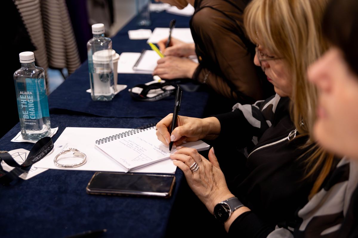 Manos escribiendo en el cuaderno del evento